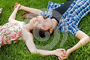 Beauty couple in love embracing lying outdoors