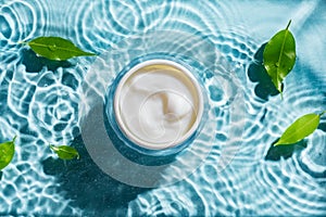 Beauty cream and green leaves on clear water