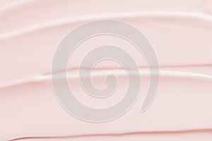 Beauty cream lotion moisturizer texture background. Pink color cosmetic cream smear smudge photo