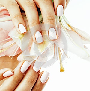 Beauty delicate hands with manicure holding flower lily close up