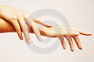 Beauty delicate hands with manicure holding flower lily close up