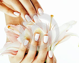 Beauty delicate hands with manicure holding flower lily close up isolated on white