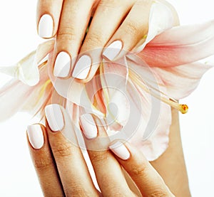 Beauty delicate hands with manicure holding flower lily close up isolated on white, spa salon concept