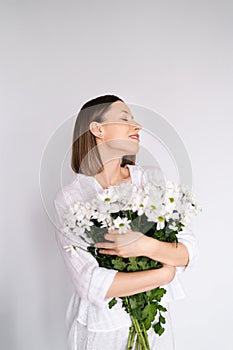 Beauty delicate woman enjoys a bouquet of white flowers
