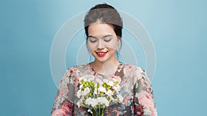 Beauty delicate woman smelling spring flowers