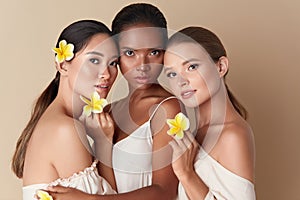 Beauty. Diverse Group Of Women Portrait. Tender Models Of Different Ethnicity Posing With Tropical Flowers In Hands.