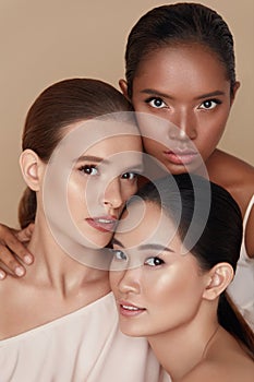 Beauty. Diverse Models Portrait. Tender Caucasian, Asian And Mixed Race Women Posing Together On Beige Background. photo