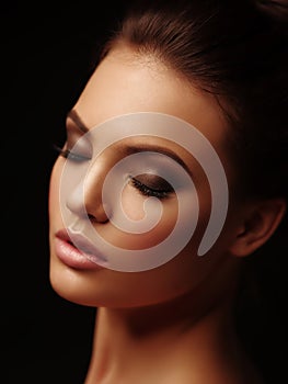 Beauty elegant portrait of a appealing naked brunette with full lips and closed eyes on the black background