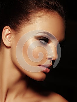 Beauty elegant portrait of a appealing naked brunette with full lips and smoky eyes make up on the black background