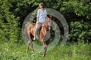 Beauty equestrian model rides a horse through a forest