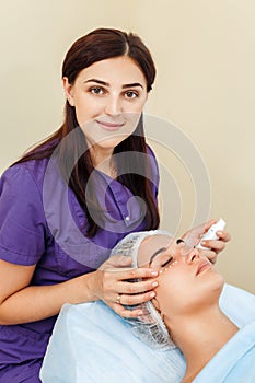 Beauty eye contour wrinkle cream or anti-aging skin care cream. young woman`s face with points of cream under the eyes