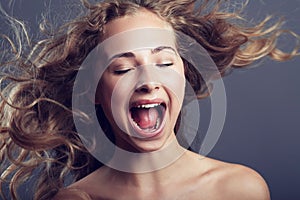 Beauty, eyes closed and hair care of woman shouting in studio isolated on a gray background. Natural, makeup cosmetics