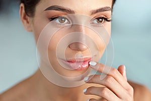 Beauty Face. Beautiful Woman Touching Lips With Lip Balm On