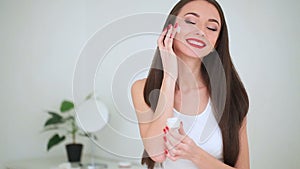 Beauty Face Care. The Portrait of Young Woman With Perfect Skin Applying Cream on Her Skin