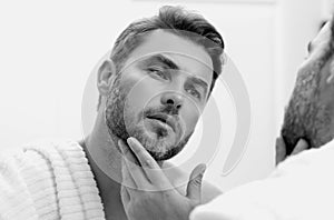 Beauty face portrait of a beautiful man applying face cream. Moisturizing skincare cream for man. Mask, skin lifting and