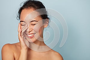 Beauty face. Smiling asian woman touching healthy skin portrait