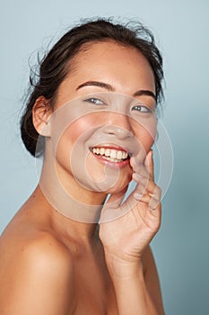 Beauty face. Smiling asian woman touching healthy skin portrait