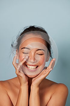 Beauty face. Smiling asian woman touching healthy skin portrait