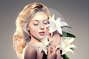 Beauty face woman, flowers, lily. Girl healthy model in spa salon. Cream treatment products. Facial skin terapy