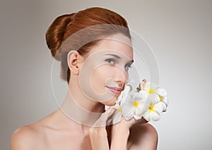 Beauty face of young beautiful woman with flower.