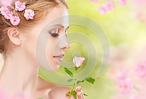 Beauty face of young beautiful woman with pink flowers in her ha