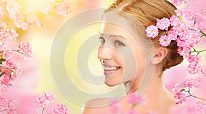 Beauty face of young beautiful woman with pink flowers in her ha