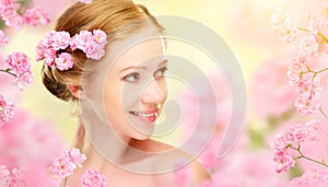 Beauty face of young beautiful woman with pink flowers in her ha