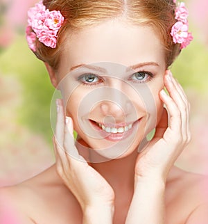 Beauty face of young happy beautiful woman with pink flowers in