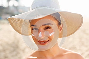 Beauty Facial Care. Young  Female Holding Bottle Sun Cream and  Applying on Face Smiling. Beauty Face.