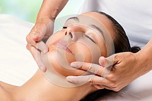 Beauty facial massage on female chin.