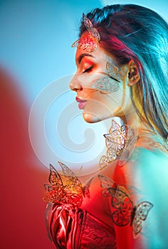 Beauty fantasy model spring girl in colorful bright neon lights. Portrait of beautiful summer young woman in UV. Art design