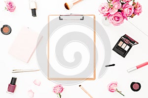 Beauty or fashion blog composition with pink roses bouquet, cosmetics, diary and clipboard on white background. Top view. Flat lay