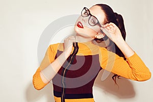 Beauty Fashion brunette model girl wearing stylish glasses. woman with perfect makeup, trendy orange and red dress