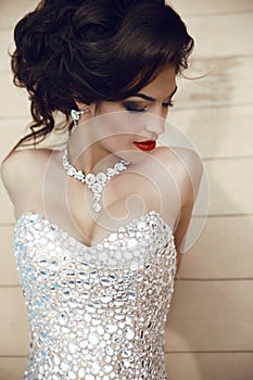 Beauty fashion brunette model portrait. Elegant lady in luxurious glamour dress with oriental gemstones and expensive jewelry. Ma