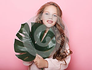 Beauty and fashion concept: Little girl wearing pink outfit and holding flower