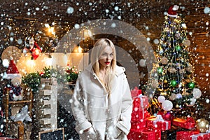 Woman in snow. Beauty fashion girl with Christmas present box. Girl is happy about the new year. Woman in evening dress