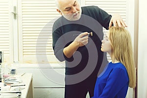 Beauty and fashion. Man applying foundation cream on girl face