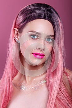 Beauty fashion model girl with colorful dyed pink hair. Girl with bright makeup and pink lips