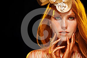 Beauty Fashion model girl with Golden Makeup, Gold skin make up, hair and jewellery on black background.