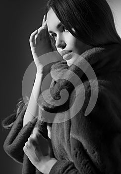 Beauty Fashion Model Girl in Mink Fur Coat black and white portrait. Beautiful Woman in Luxury Brown Fur Jacket posing in studio