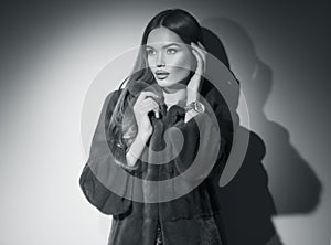 Beauty Fashion Model Girl in Mink Fur Coat black and white portrait. Beautiful Woman in Luxury Brown Fur Jacket posing