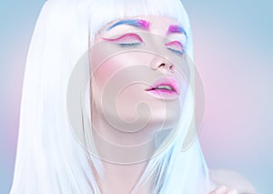 Beauty fashion model girl portrait with white hair, pink eyeliner, gradient lips. Futuristic makeup in white, blue and pink co