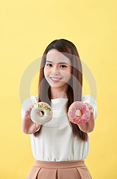 Beauty fashion model girl taking sweets and colorful donuts