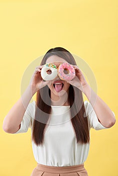 Beauty fashion model girl taking sweets and colorful donuts