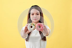 Beauty fashion model girl taking sweets and colorful donuts