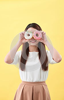 Beauty fashion model girl taking sweets and colorful donuts