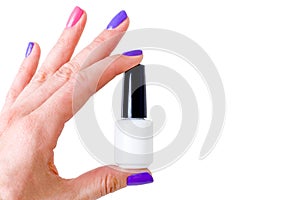 Beauty, fashion and Nail art concept. Woman hand with colorful manicure pink and purple colors close-up with white bottle of gel n