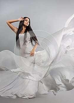 Beauty fashion photo of young beautiful girl in a flying white cloth.