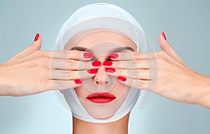 Beauty, Fashion and Plastic Surgery concept. Woman covering eyes with bandaged head