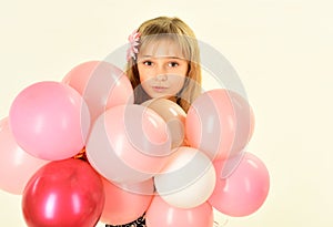 Beauty and fashion, punchy pastels. Little girl with hairstyle hold balloons. Small girl child with party balloons